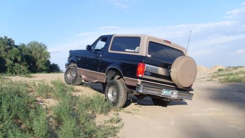 1996 Ford Bronco - This 1996 Ford Bronco is seen off-road on a sandy hill under a clear blue sky.