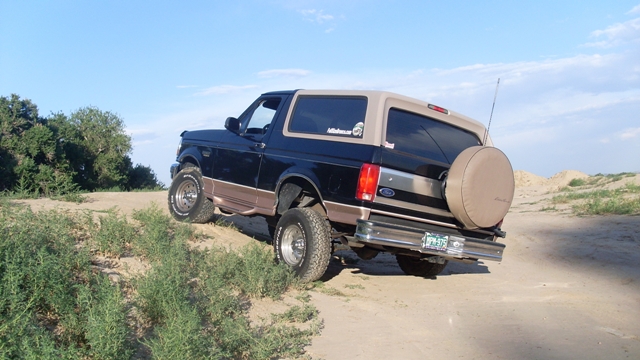 Black and tan 1996 Ford Bronco on sandy incline
