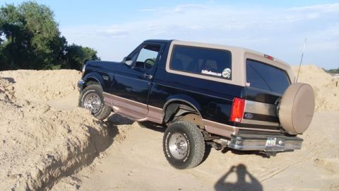 1996 Ford Bronco - This 1996 Ford Bronco navigates a sandy incline under a clear blue sky.