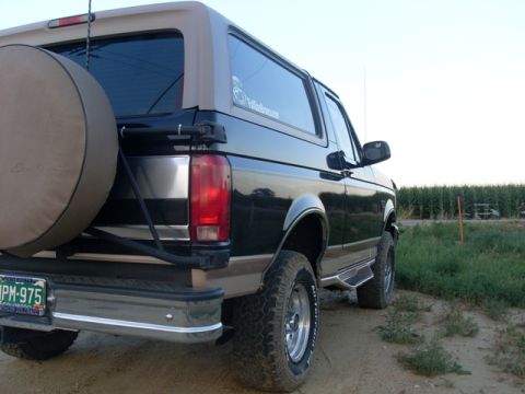 1996 Ford Bronco - Rear view of a 1996 Ford Bronco with a spare tire cover, parked outdoors.