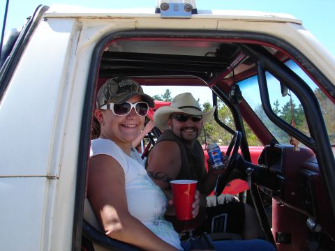 1996 Ford Bronco - Two people are enjoying a day out in a vehicle, holding drinks.