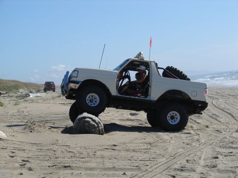 1996 Ford Bronco - Modified 1996 Ford Bronco navigating sand dunes with a second vehicle visible in the distance.