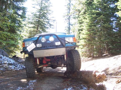 1991 Ford Bronco - This modified Ford Bronco navigates a wooded trail with a fallen log.