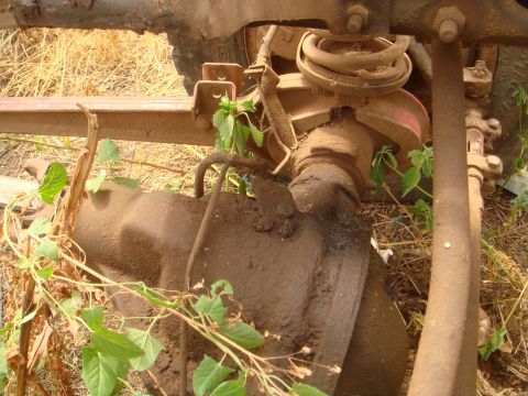 1992 Ford Bronco - Mud-covered vehicle suspension and differential parts are visible in this close-up shot.