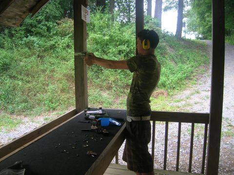 1996 Ford Bronco - A person practices shooting a handgun at an outdoor range, with spent casings on the table.