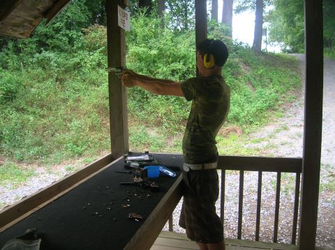 1996 Ford Bronco - A person practices shooting at an outdoor range, with spent casings scattered on the table.