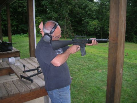 1996 Ford Bronco - A man practices shooting at an outdoor range, holding a rifle with ear protection on.