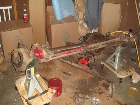 1992 Ford Bronco - A disassembled front axle assembly is shown supported by jack stands in a workshop environment.
