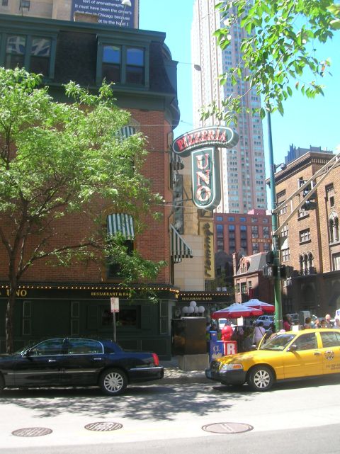 1996 Ford Bronco - A street scene shows the Pizzeria Uno restaurant with a black sedan and a yellow taxi on the road.