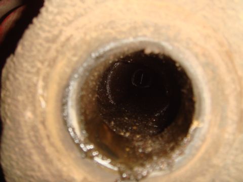 1992 Ford Bronco - This image shows a close-up view of a drain opening, filled with debris and liquid, suggesting a potential blockage or maintenance issue.