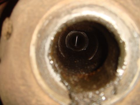 1992 Ford Bronco - Close-up view looking into a spark plug hole, showing the electrode at the bottom.