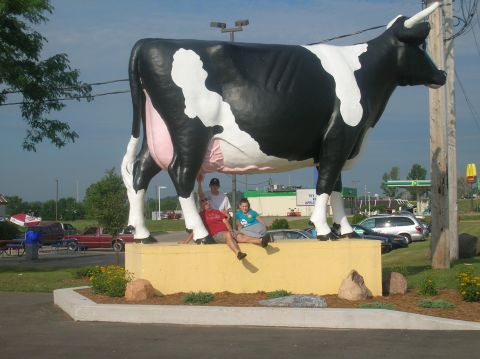 1996 Ford Bronco - People pose with a large cow statue outside a roadside business.