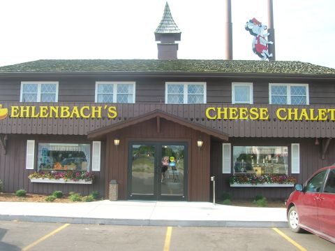 1996 Ford Bronco - A red car is parked in a lot outside the Ehlenbach's Cheese Chalet.