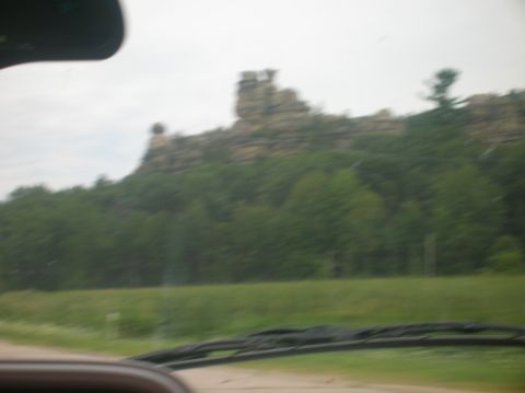 1996 Ford Bronco - Driving past a large rock formation with trees on a cloudy day.
