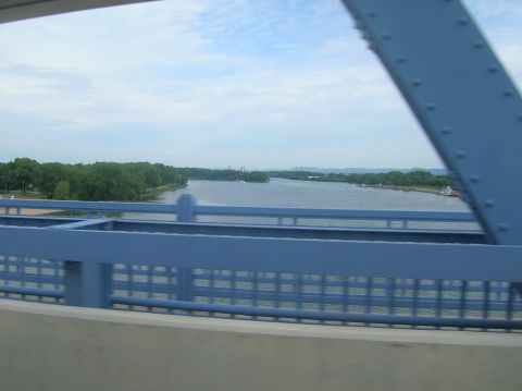 1996 Ford Bronco - View from a bridge overlooking a river with trees lining the distant shore under a cloudy sky.