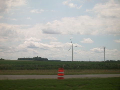 1996 Ford Bronco - A landscape scene wind turbines against a backdrop of clouds and fields, with a traffic barrel in the foreground.
