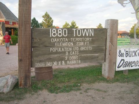 1996 Ford Bronco - A weathered wooden sign details the population of 1880 Town, including ghosts, cats, dogs, and rabbits.