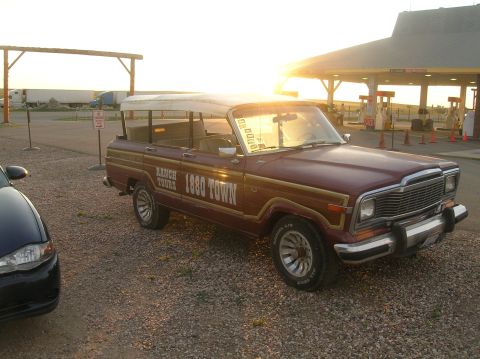 1996 Ford Bronco - Maroon Jeep Grand Wagoneer with "Ranch Tours 1880 Town" text on the side.