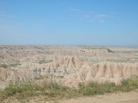 1996 Ford Bronco - A vast expanse of eroded rock formations stretches to the horizon under a bright blue sky.