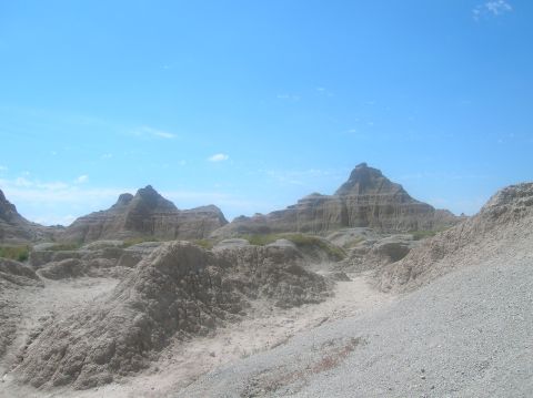 1996 Ford Bronco - The terrain of the Badlands National Park features eroded buttes and pinnacles under a bright blue sky.