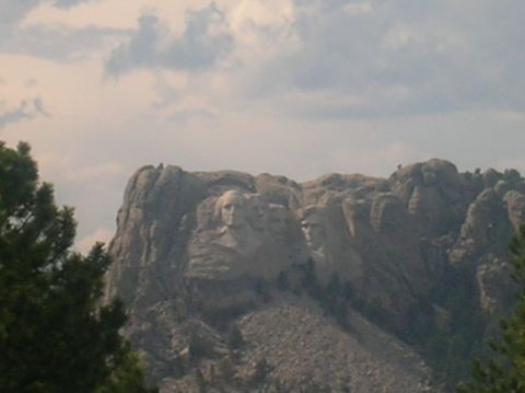 1996 Ford Bronco - The iconic Mount Rushmore National Memorial, carved presidential faces, is seen under a cloudy sky.