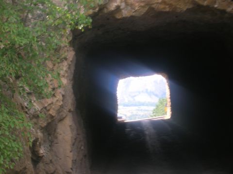 1996 Ford Bronco - Looking out from a tunnel reveals a distant landscape with mountains under bright sunlight.