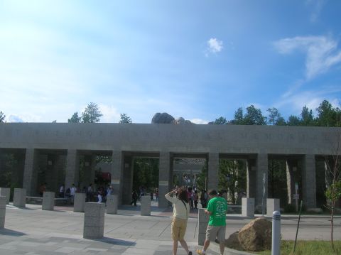 1996 Ford Bronco - The entrance to Mount Rushmore National Memorial features a large stone structure with carved text and multiple archways.