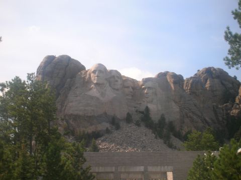 1996 Ford Bronco - A view of Mount Rushmore National Memorial, carved presidential faces, with trees in the foreground.