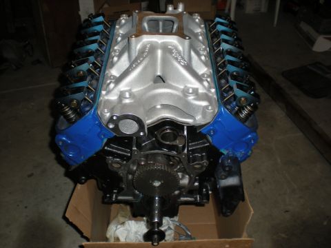 1985 Ford Bronco - A V8 engine with blue valve covers and a silver intake manifold is shown, ready for installation.