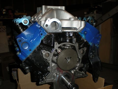 1985 Ford Bronco - Engine block with blue valve covers and silver intake manifold, front view.