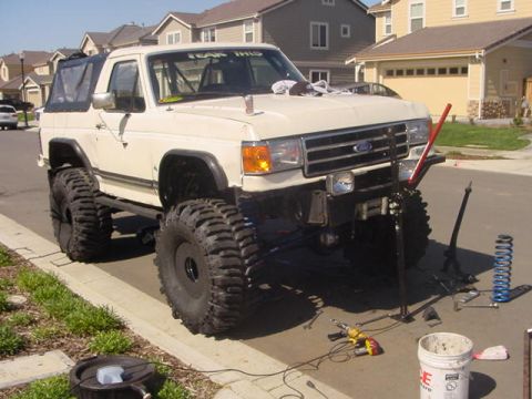 1991 Ford Bronco - This 1991 Ford Bronco is undergoing suspension modifications with large tires and tools laid out.