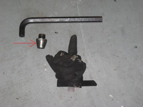 1991 Ford Bronco - Tools for changing a tire: a lug nut and a hex wrench.