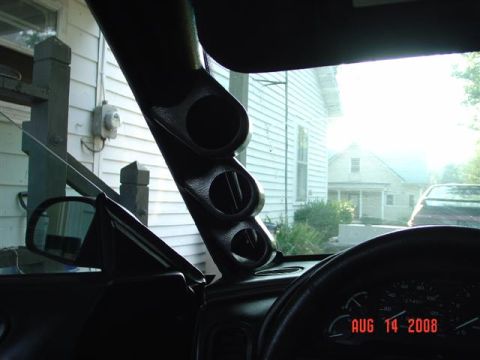 1993 Ford Probe - A custom gauge pod is installed on the A-pillar inside a vehicle, with a view of houses and another car through the windshield.