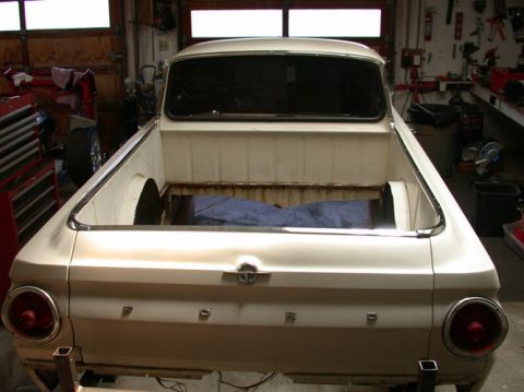 1964 Ford Ranchero - Rear view of a white 1964 Ford Ranchero in a workshop, with the bed open.