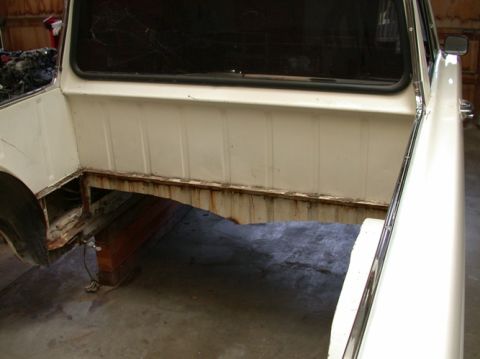 1964 Ford Ranchero - The rear bed and frame of a white pickup truck show significant rust and damage.