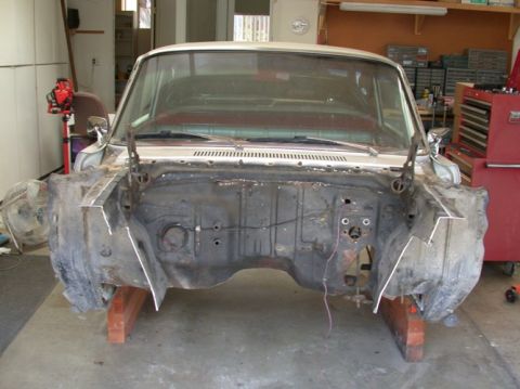 1964 Ford Ranchero - The front end of a car is removed, revealing the engine bay and firewall in a garage setting.