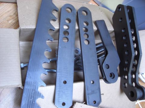 1993 Ford Bronco - Several custom metal suspension components are laid out, possibly for an off-road vehicle.
