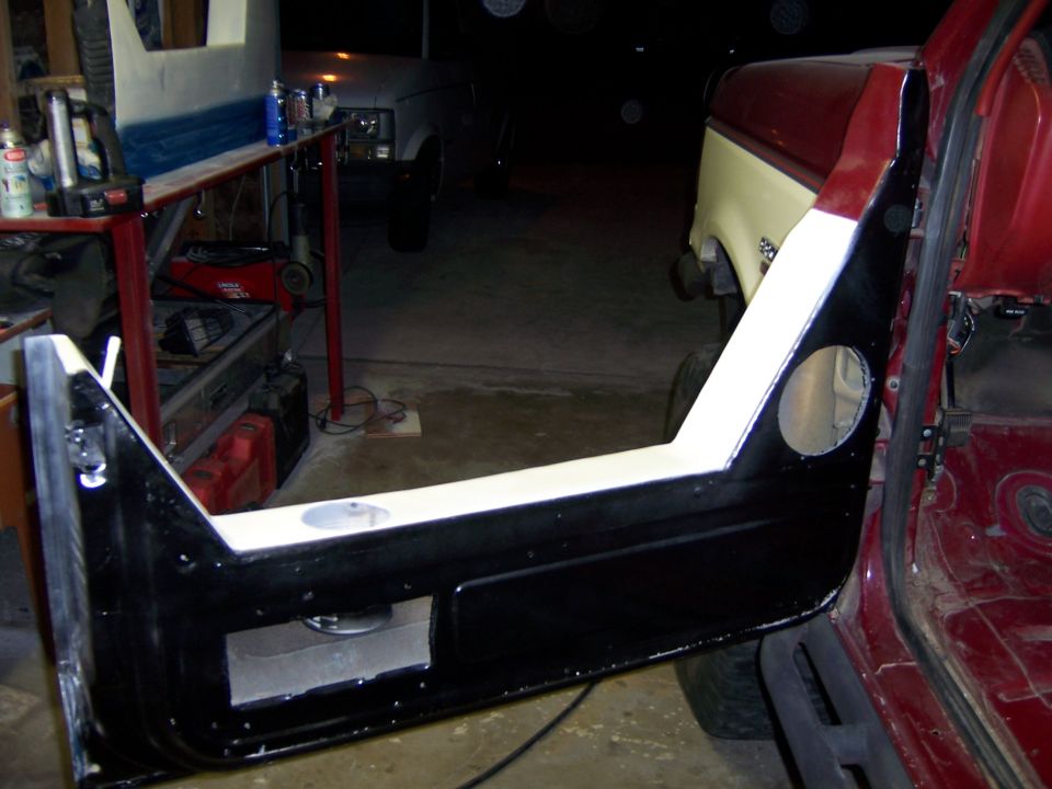 Red vehicle interior with open door, speaker cutouts. Two-tone vehicle in background