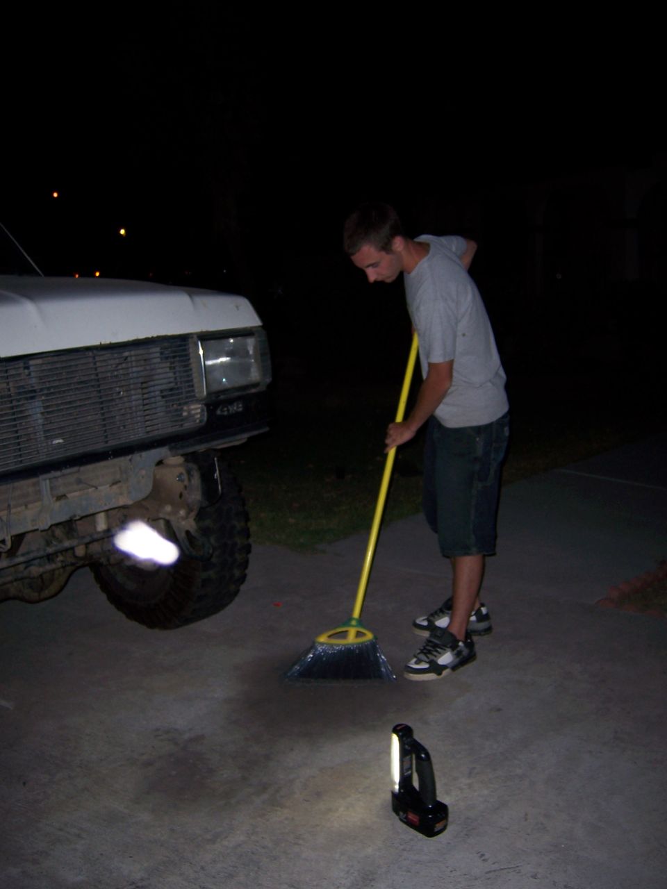 1991 Ford Bronco front end with a person sweeping the driveway