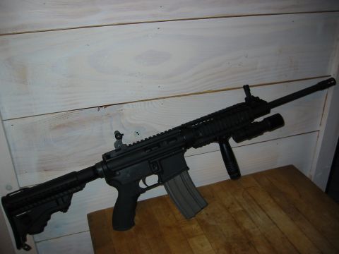 1996 Ford Bronco - An assault rifle with tactical accessories is displayed on a wooden table.