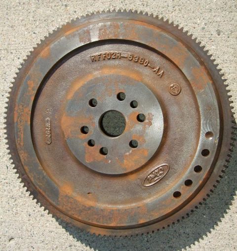 1992 Ford Probe - A rusty Ford flywheel, part number RFF02R-9380-AA, is shown resting on a concrete surface.