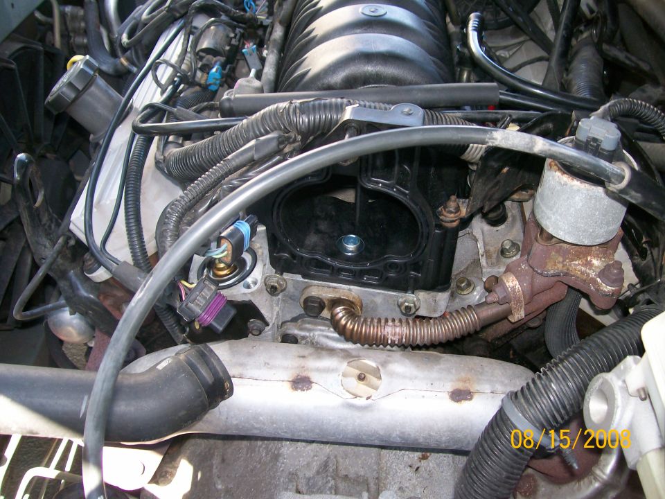 Engine bay with various hoses, wires, and engine components visible. A date stamp reads 08/15/2006