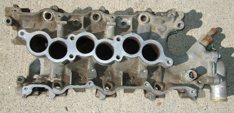 Aluminum intake manifold with six intake ports and some attached plumbing