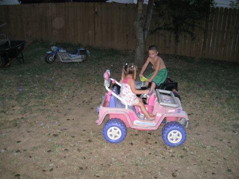 1994 Ford Bronco - Children play with toy vehicles in a backyard setting.
