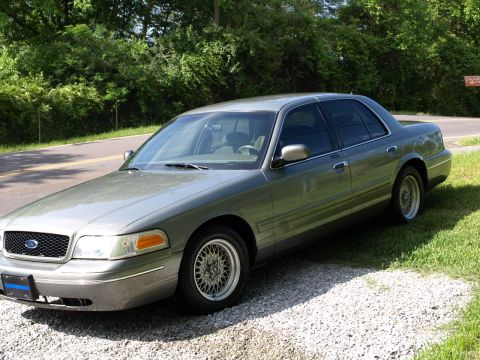 1999 Ford Crown Victoria - This 1999 Ford Crown Victoria sedan is seen parked on a gravel area next to a grassy roadside.