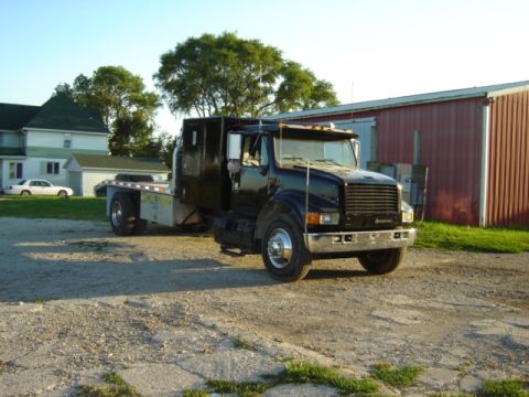 1992 Ford Bronco - Flatbed truck parked outside a barn and house.