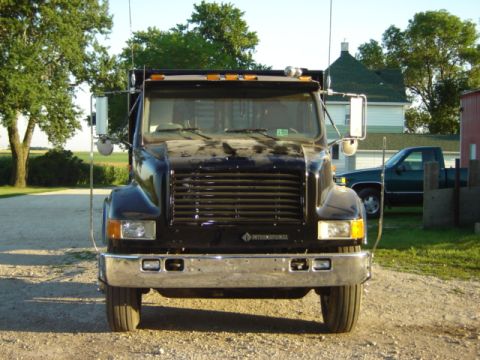 1992 Ford Bronco - A black International truck is parked in front of a house with another pickup truck in the background.