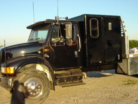 1992 Ford Bronco - This black truck features a custom sleeper cab and a large front tire, suggesting it is a heavy-duty vehicle.