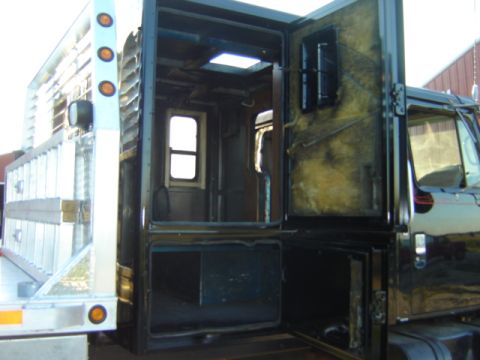 1992 Ford Bronco - The interior of a truck's custom-built rear compartment is exposed, revealing insulation and a window.