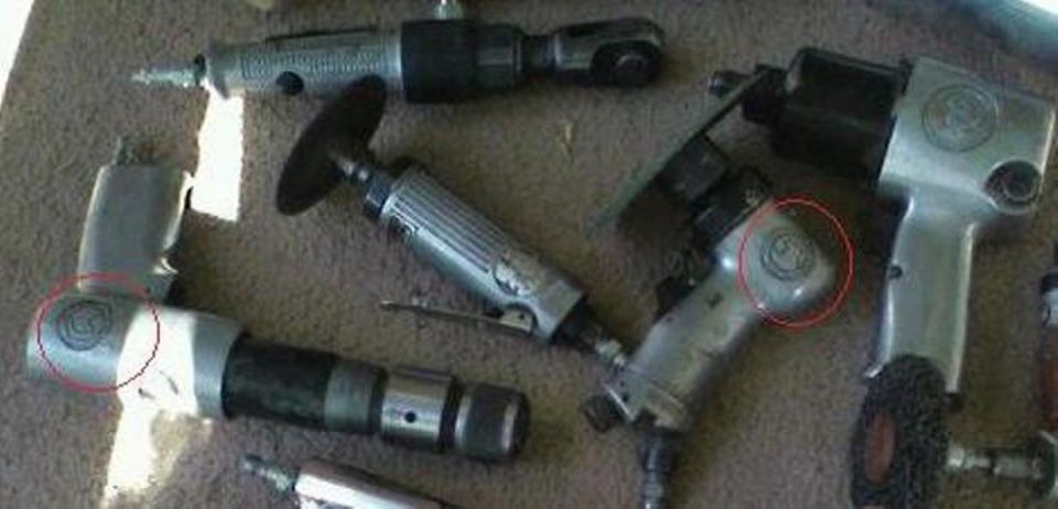 Several pneumatic air tools laid out on carpet